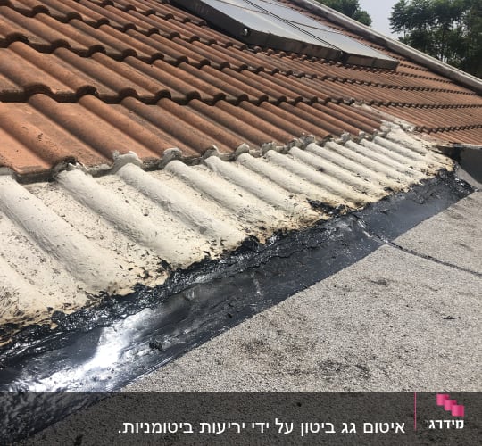 איטום גג עם חומר שחור בין רעפים